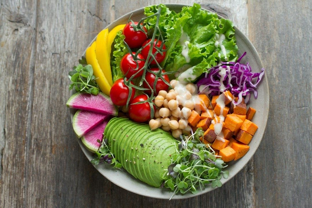 Färgstark salladstallrik med grönsaker, kikärter och avokado